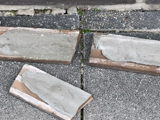 바닥에 떨어진 벽돌타일 뒷면에 접착 몰탈이 그대로 붙어 있는 현장 사진